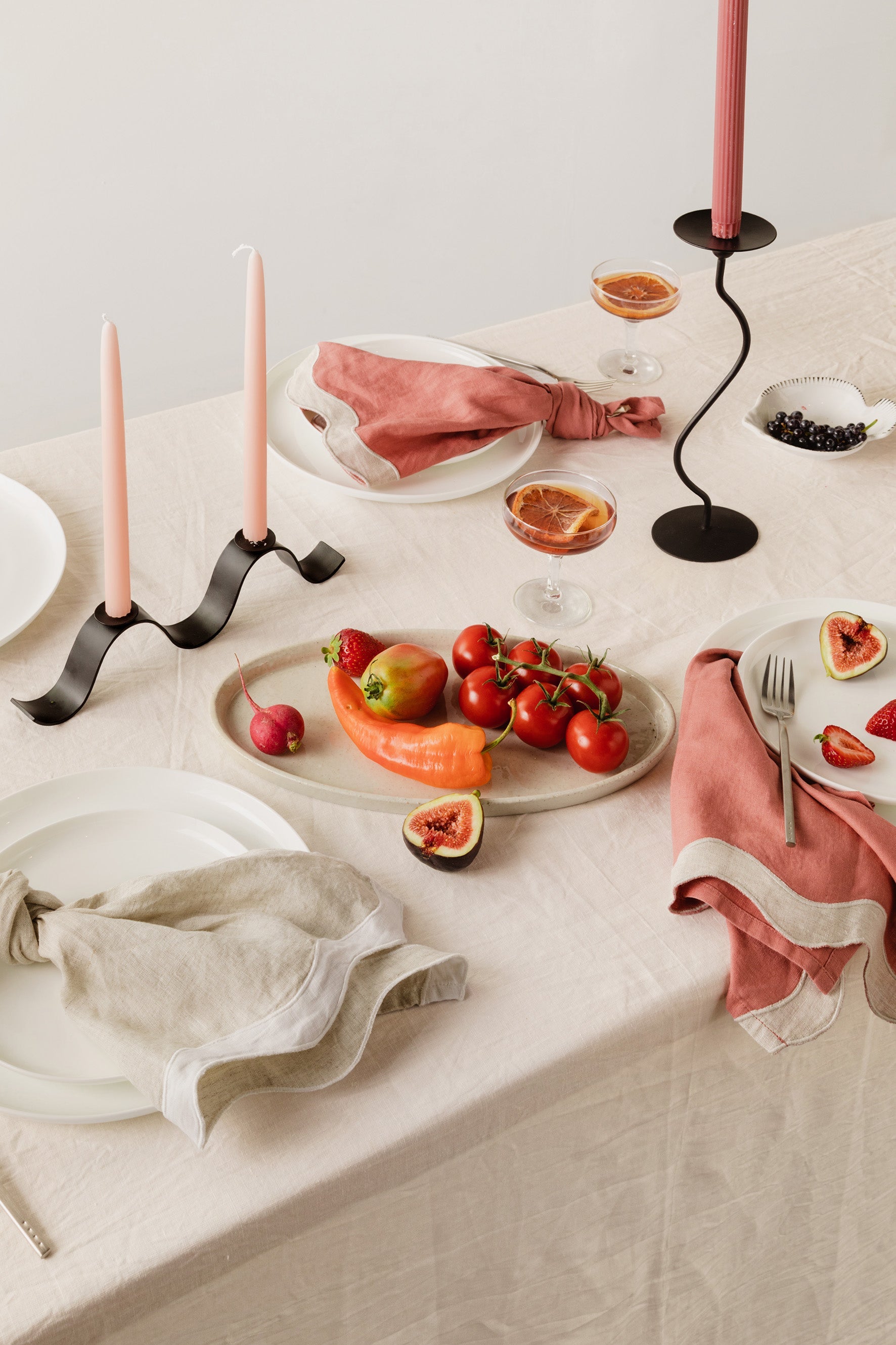 Tablescape of napkins, ceramics, and food sitting on a table