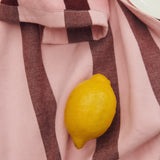 striped pink and red tea towel on floor with lemon