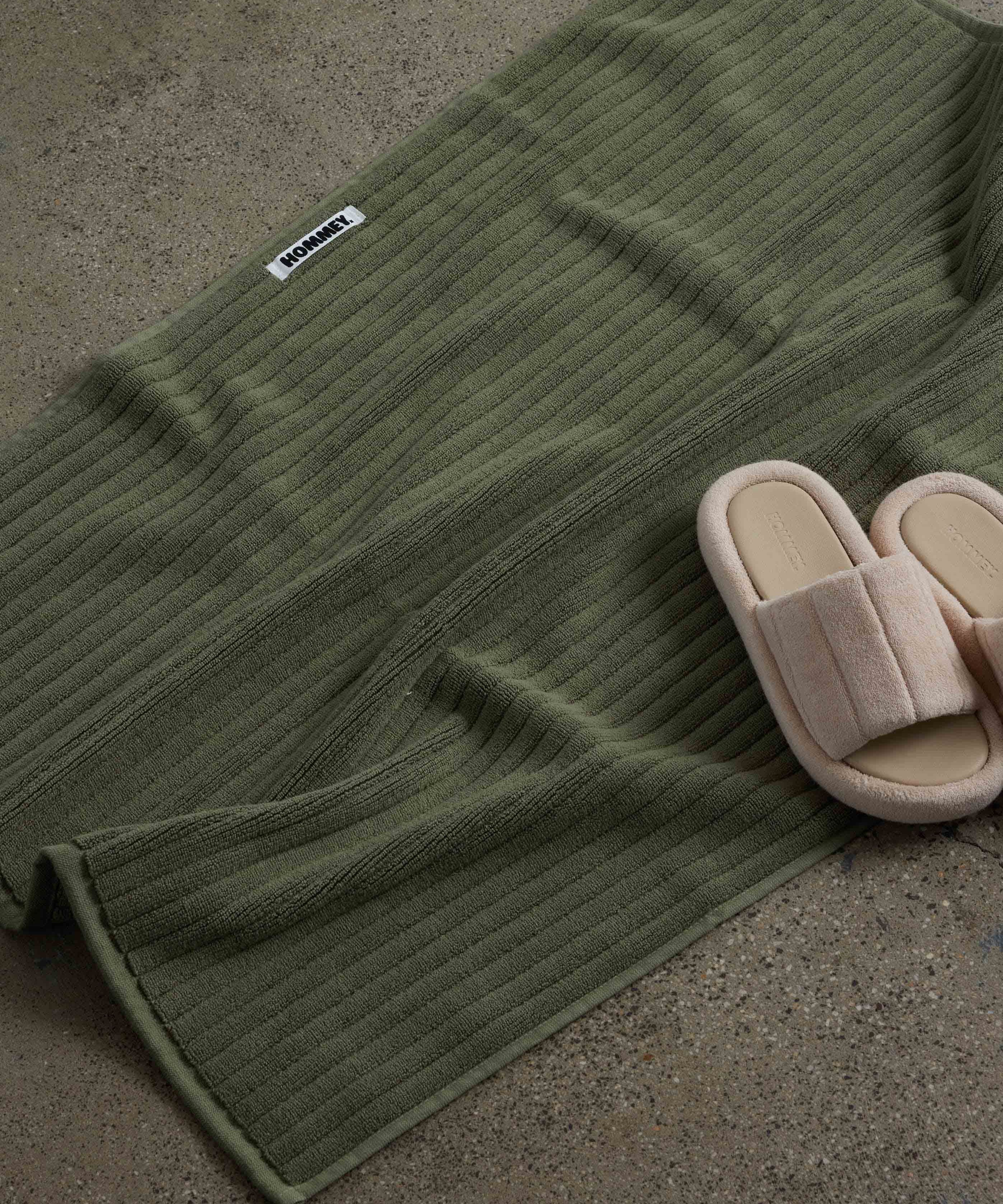 shoes next to dark green bath mat