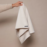 white towel being held up by woman