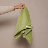 girl holding up green hand towel