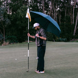 man with umbrella on gold course