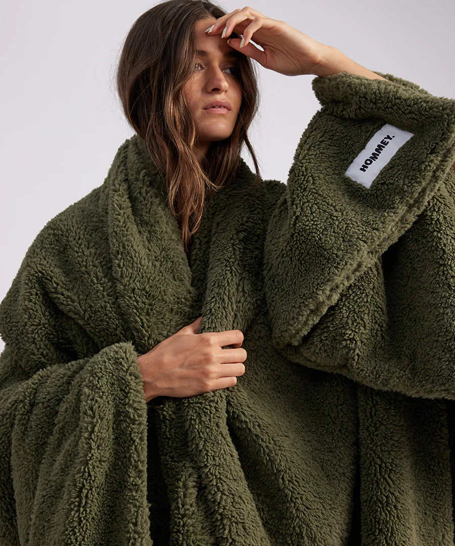 woman standing with green fluffy throw blanket around her
