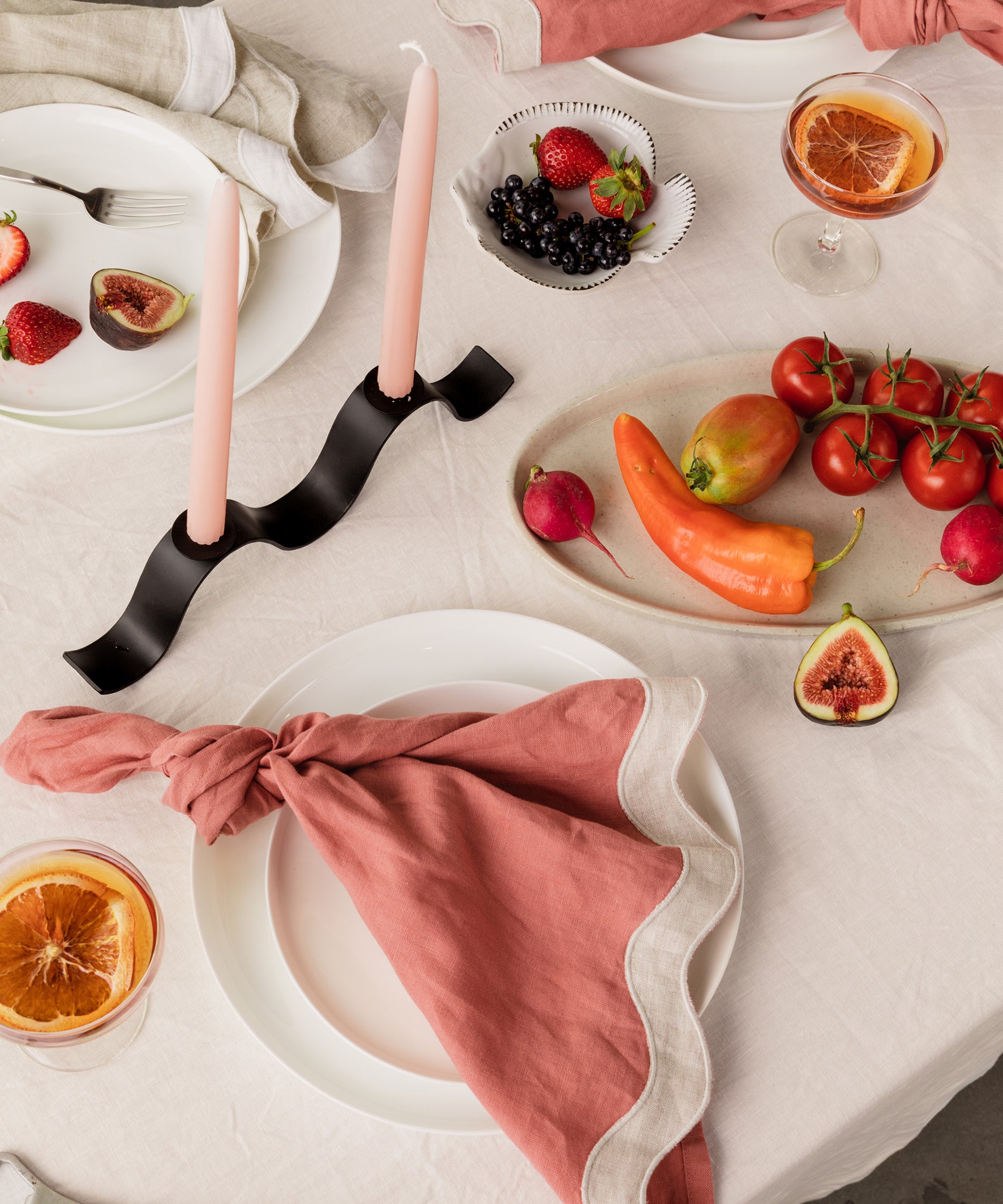 tablescape of food, wavy napkins, and ceramics