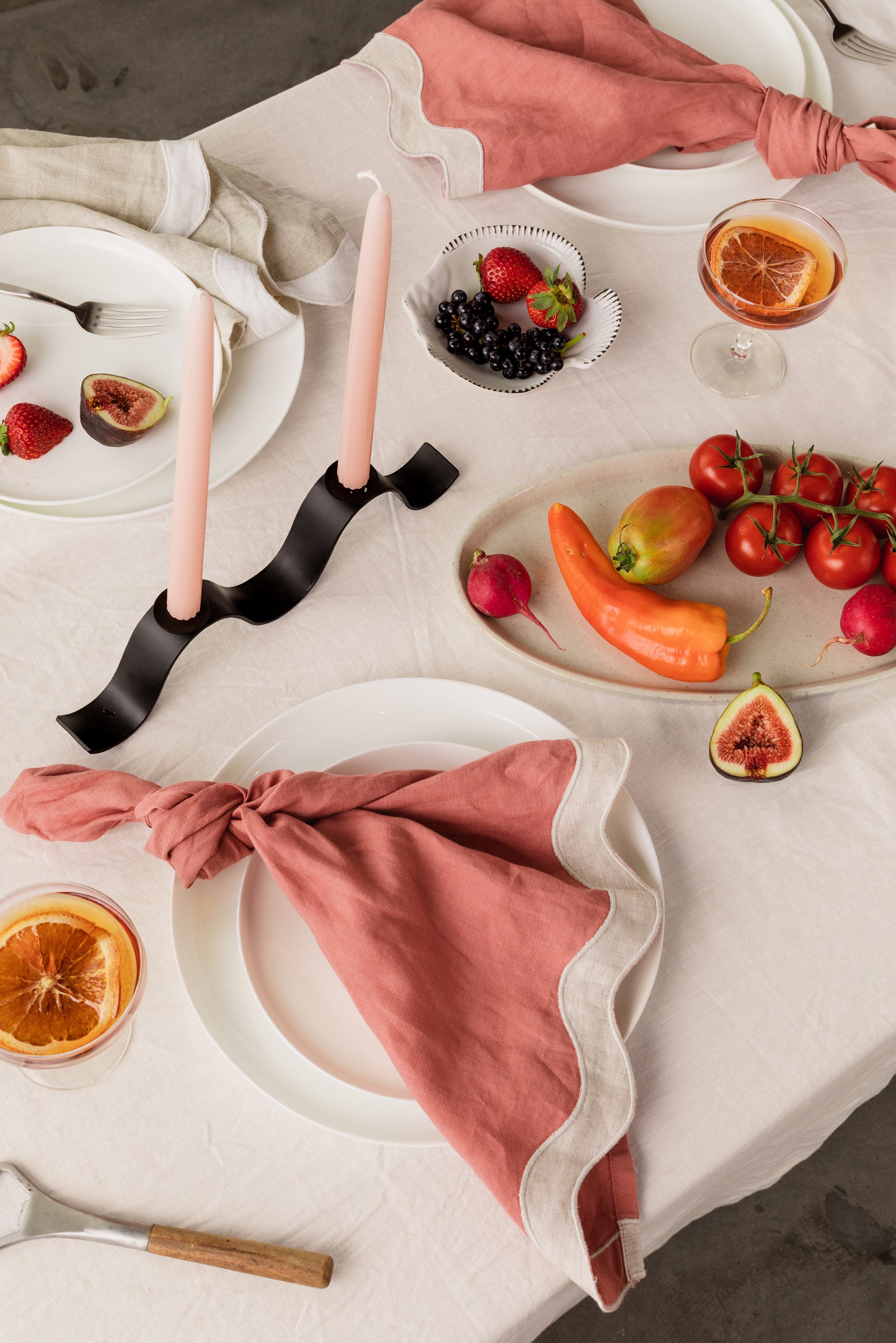 tablescape of food, wavy napkins, and ceramics