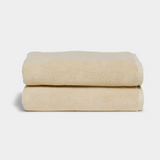 Soft beige bath towel - Coconut, spa-quality cotton towels stacked neatly