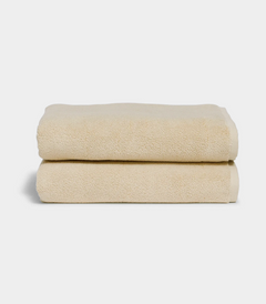 Soft beige bath towel - Coconut, spa-quality cotton towels stacked neatly
