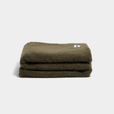 Olive green faux fur throw blanket folded on white background