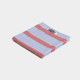 Folded blue and red striped cotton tea towel with Hommey label on white background