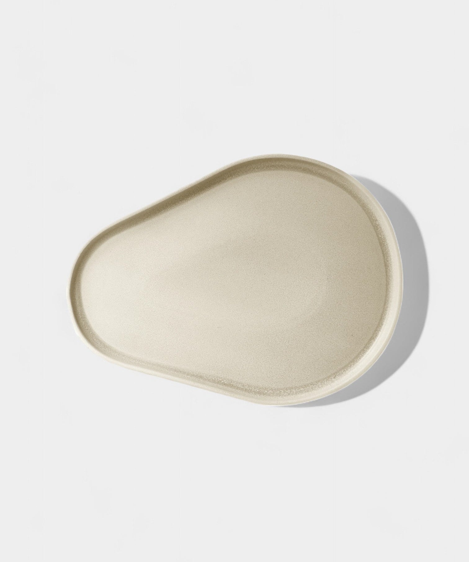 Cream clay serve plate with oatmeal fleck and modern profile in sand color, microwave and dishwasher safe