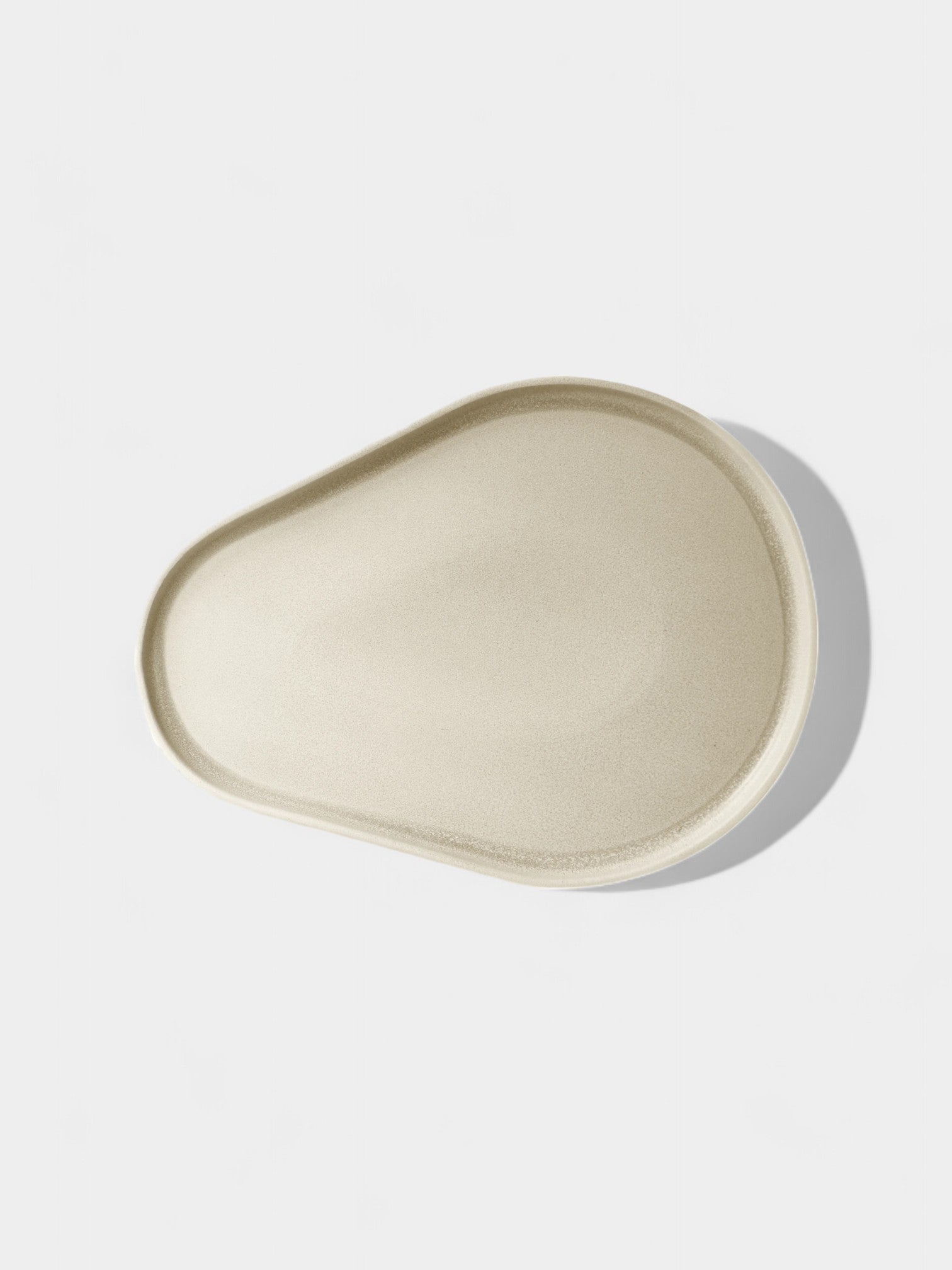 Cream clay serve plate with oatmeal fleck and modern profile in sand color, microwave and dishwasher safe