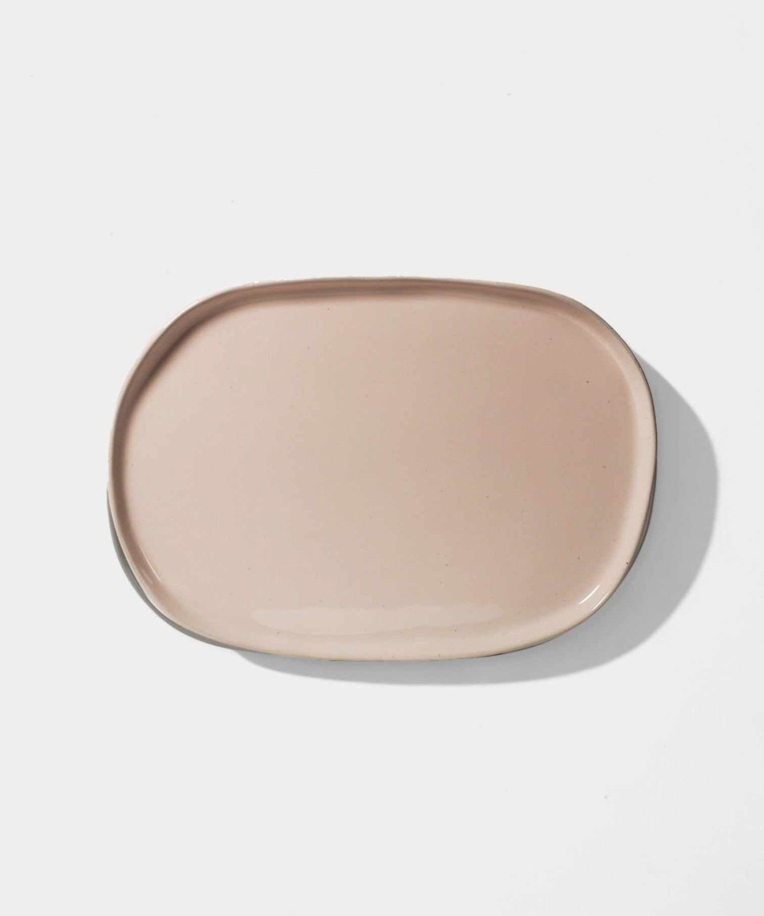 Oval blush ceramic platter with an organic handcrafted design for serving appetizers.