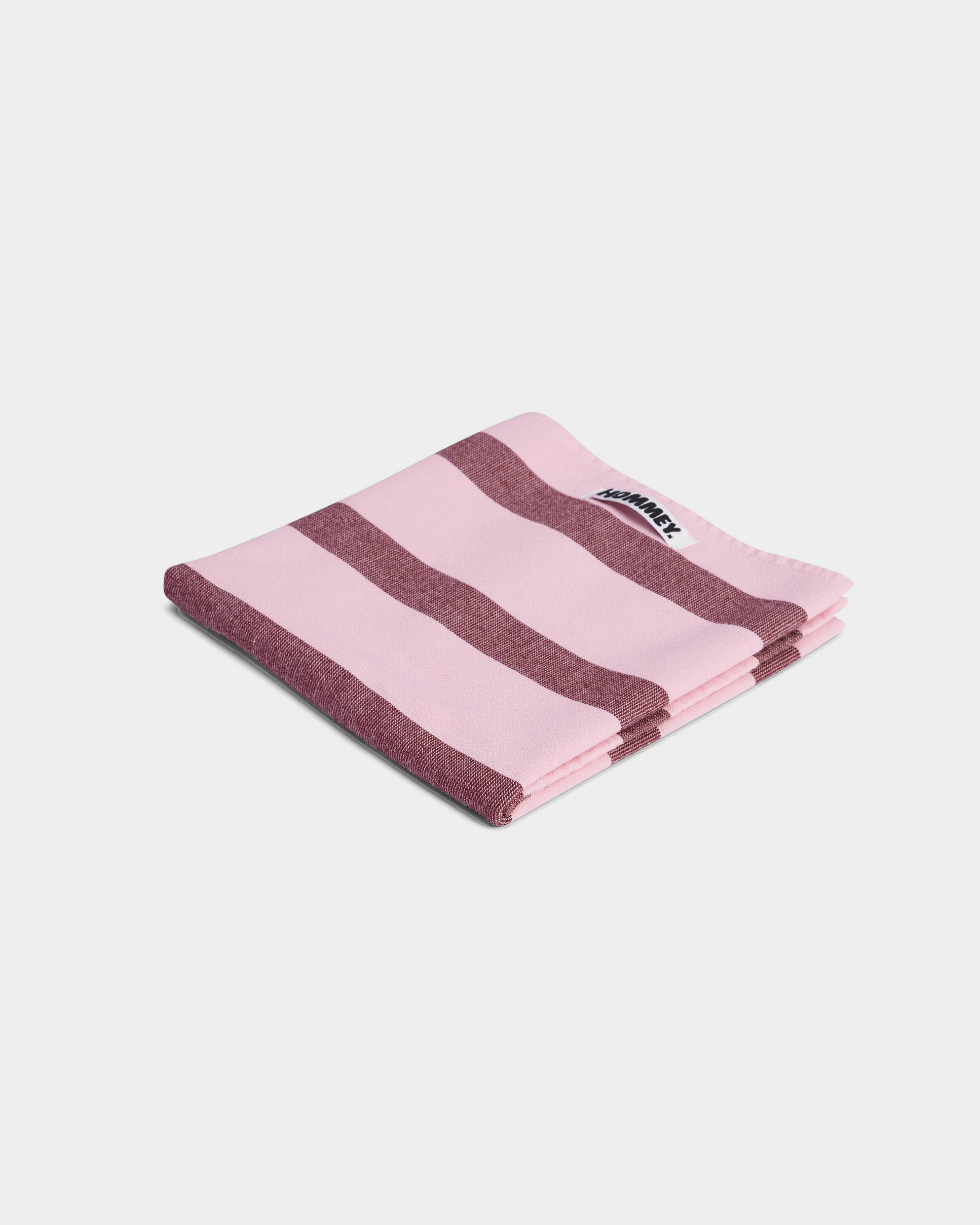 Folded pink and brown striped cotton tea towel with Hommey label