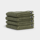 Stack of sage green face washer towels neatly folded for a spa-like home experience
