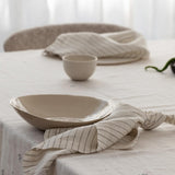 napkins and bowls sitting on a table with a tablecloth on it