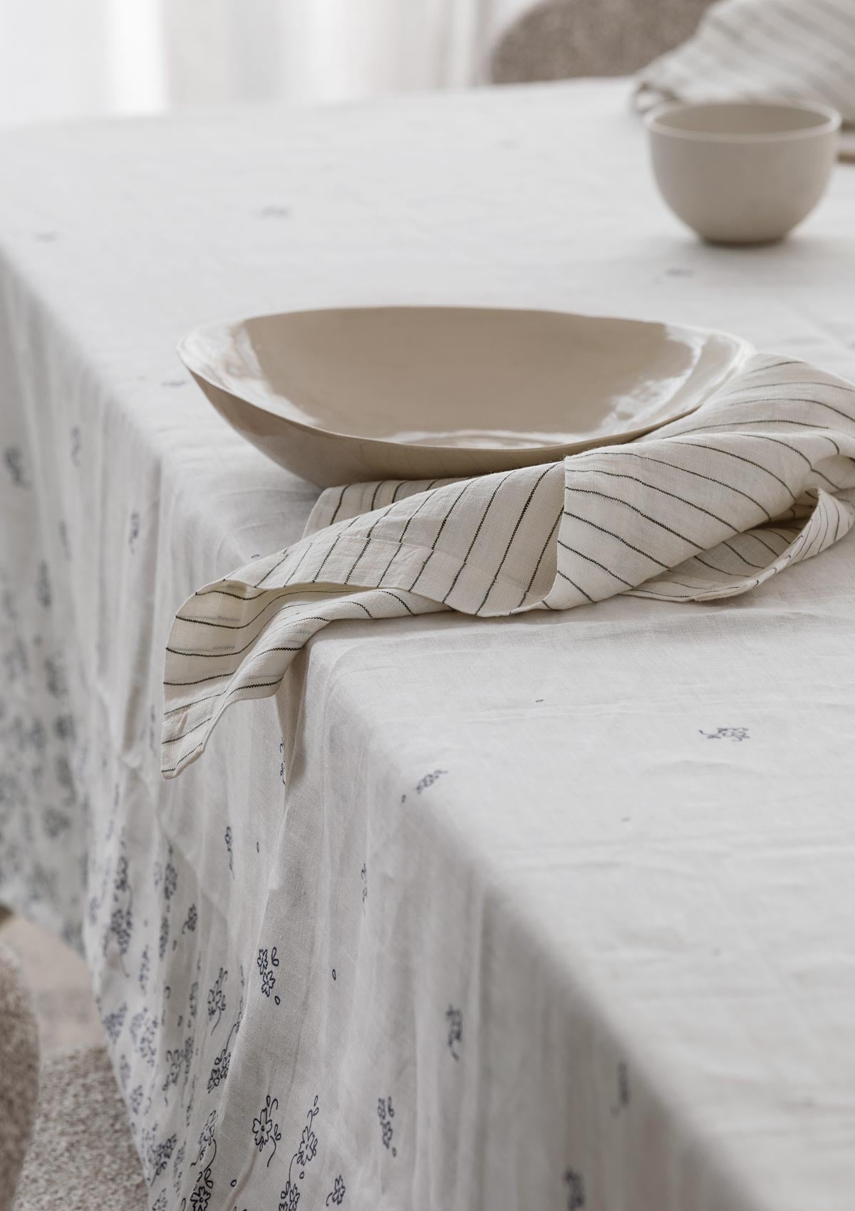 striped linen napkin sitting on a table with a tablecloth on it