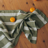 green and grey striped tea towel on floor with mandarins