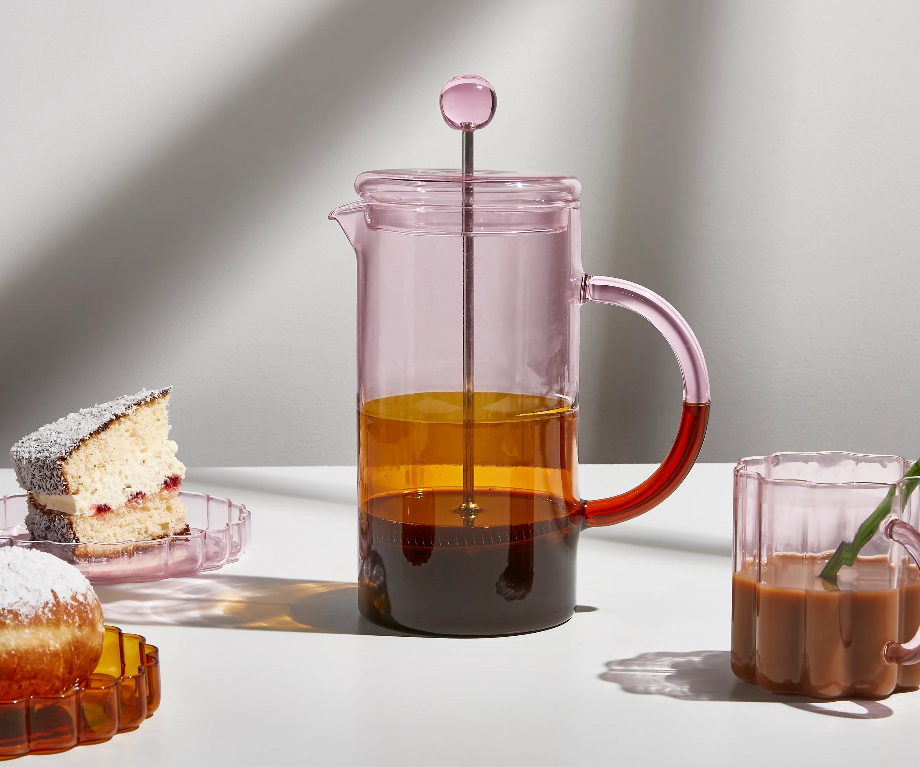 pink coffee plunger lifestyle shot with muffins in back
