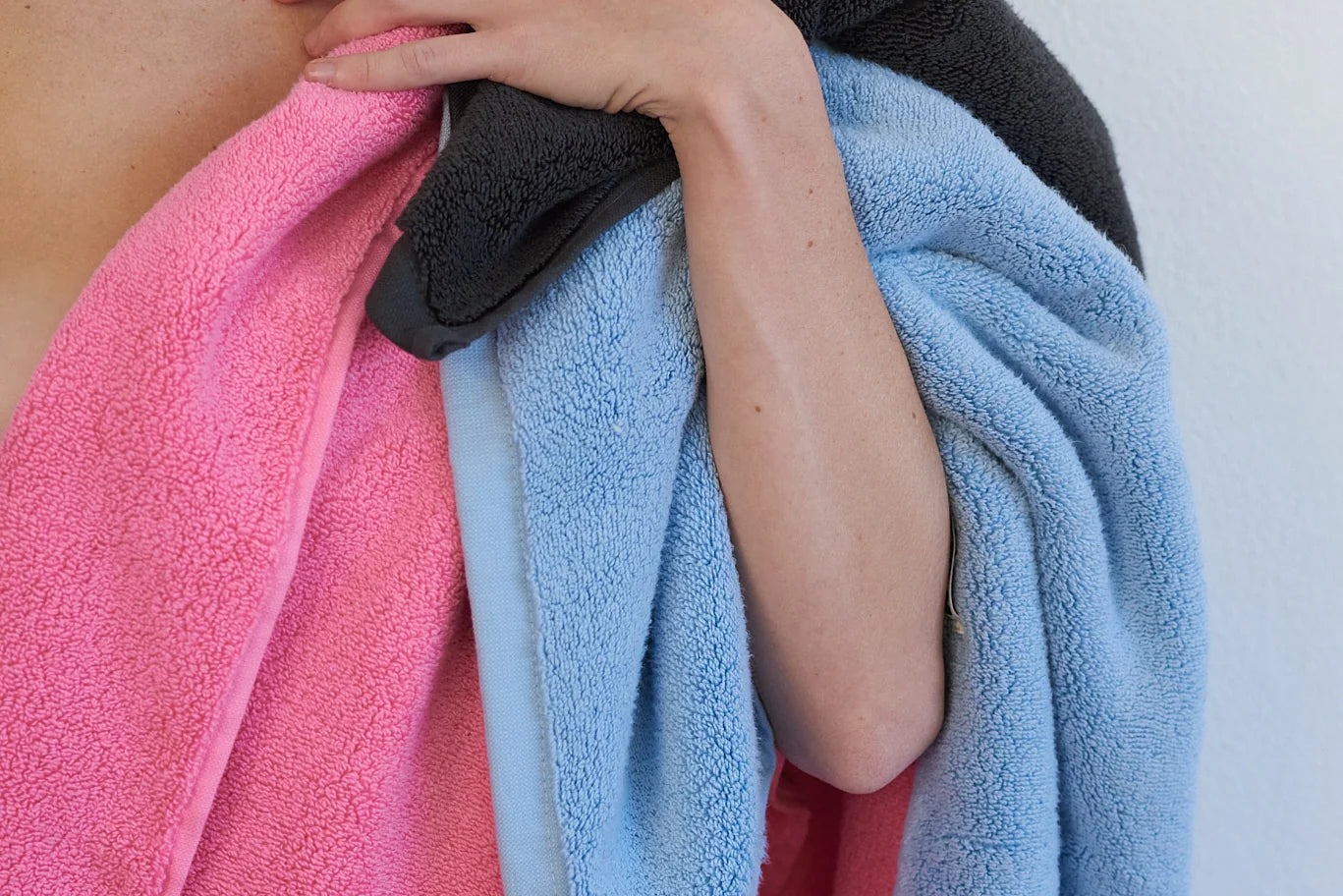 different coloured towels slung over womans shoulder