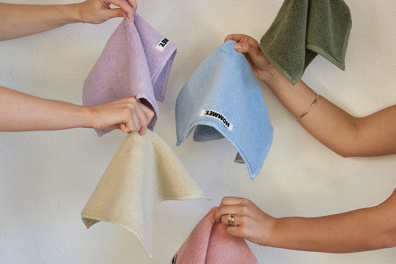 many people holding up different coloured towels