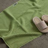 shoes next to white green bath mat