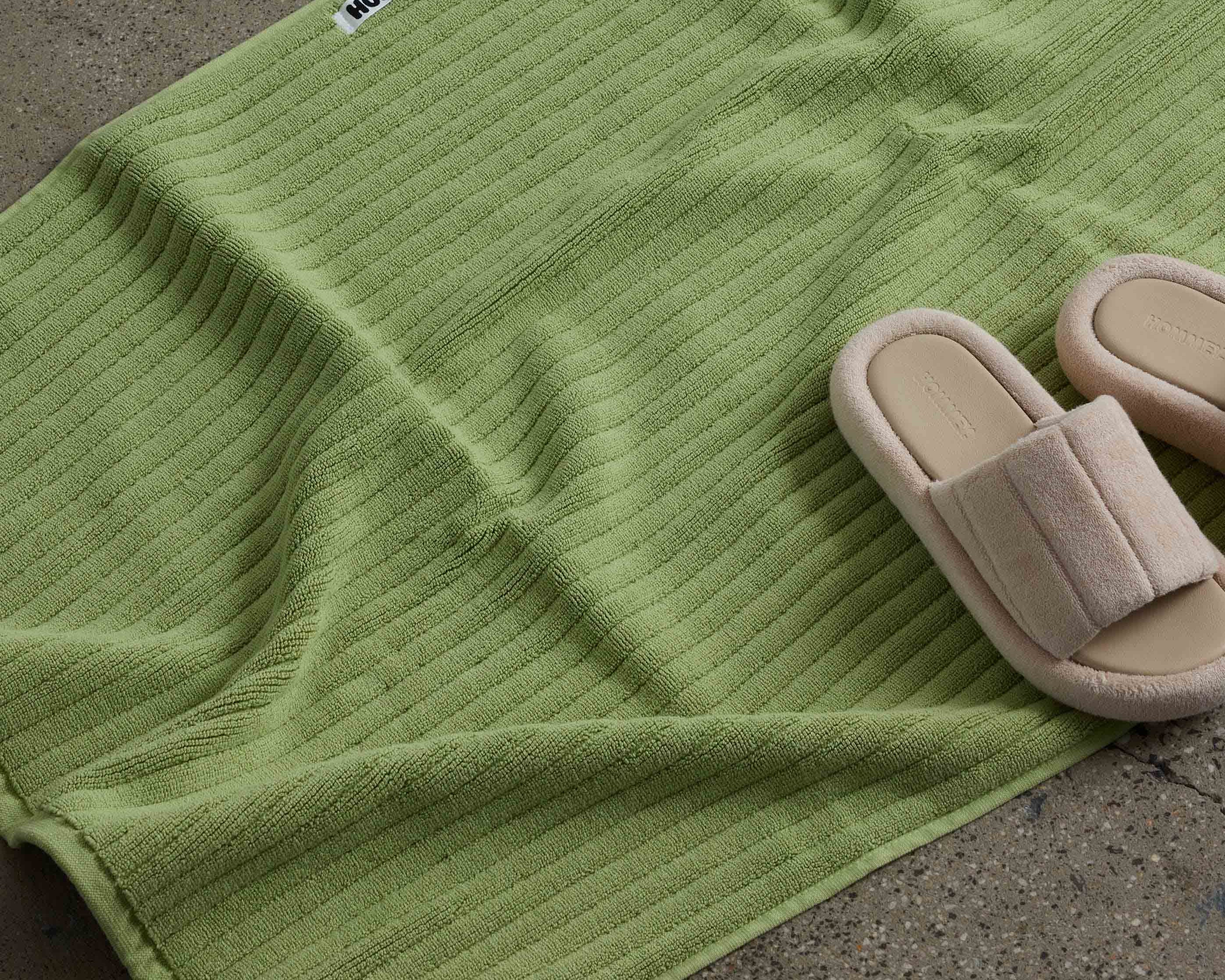 shoes next to white green bath mat