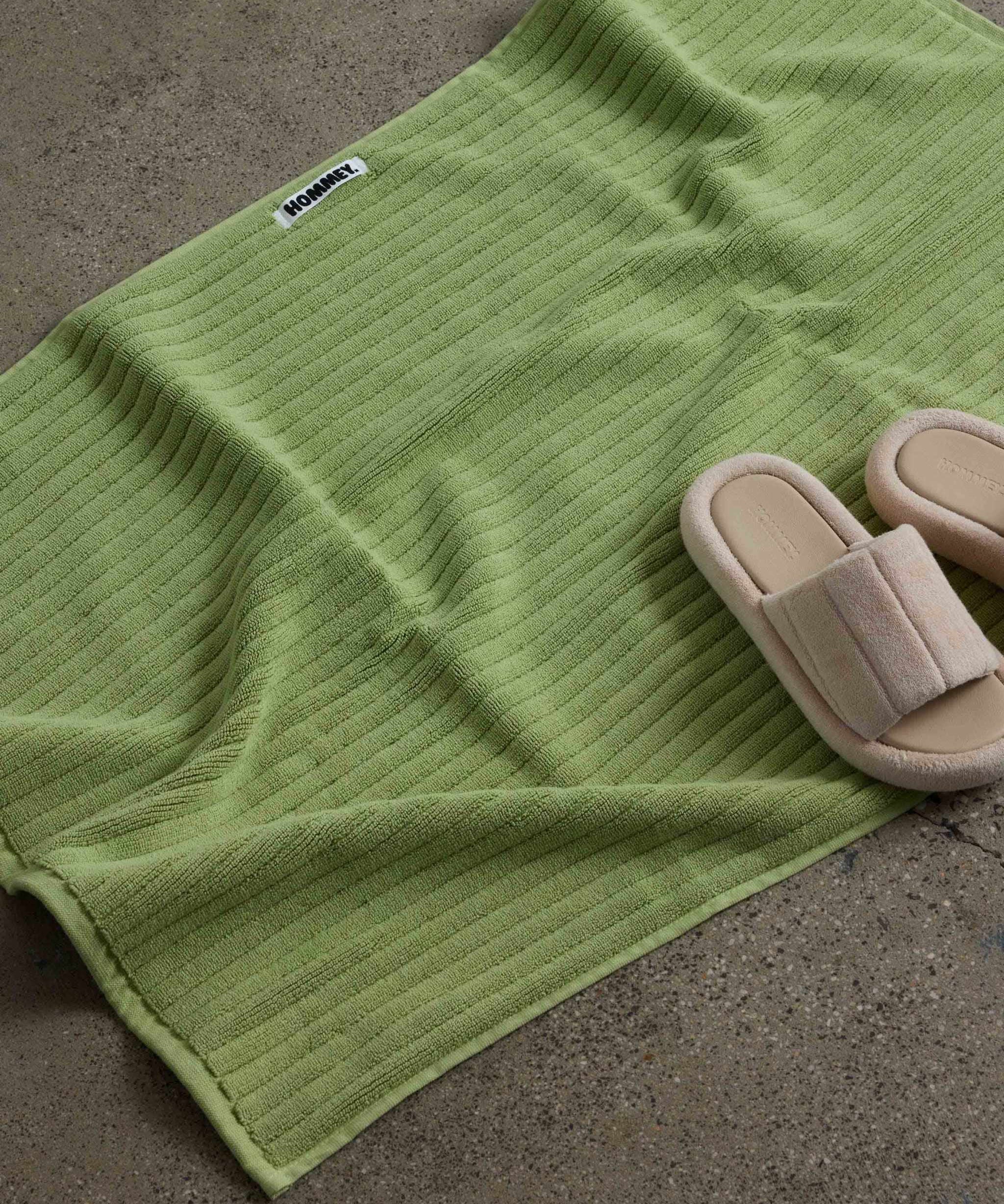 shoes next to white green bath mat