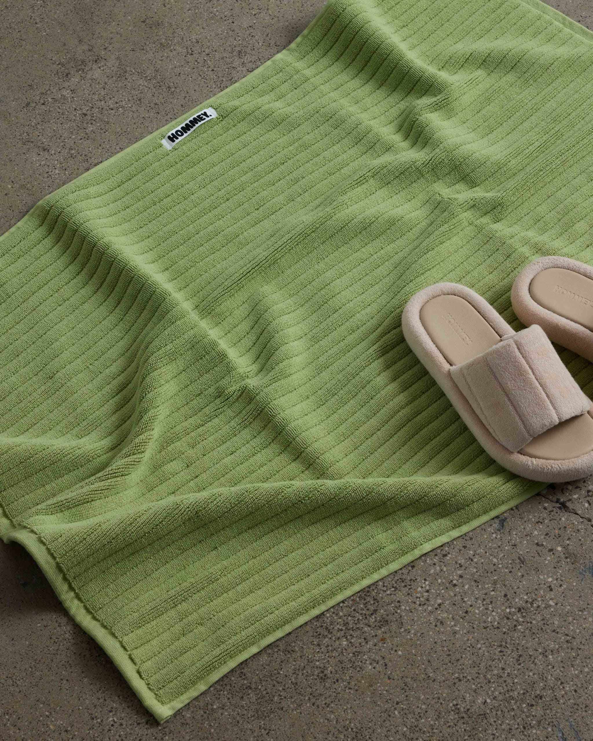 shoes next to white green bath mat