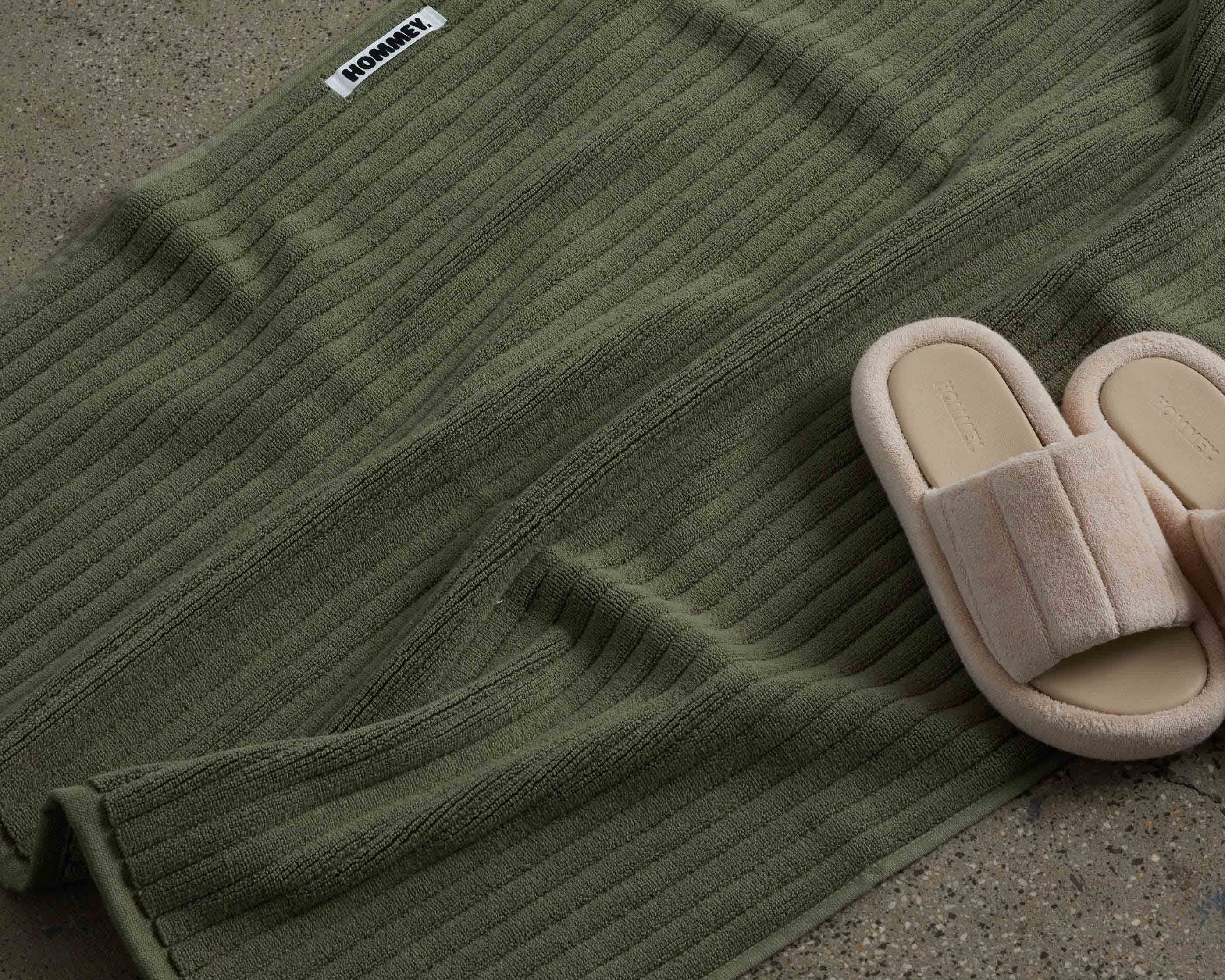 shoes next to dark green bath mat 