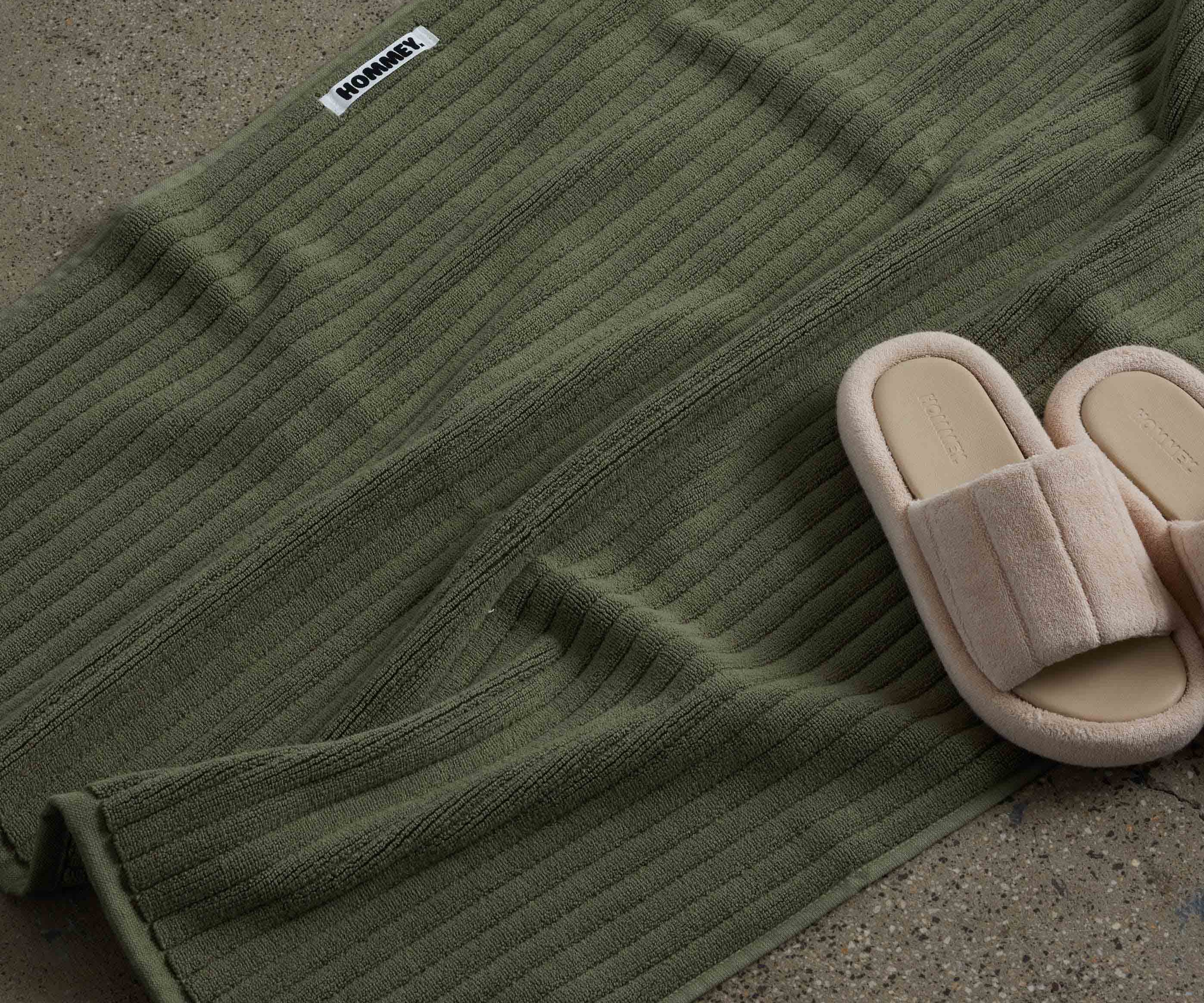 shoes next to dark green bath mat 
