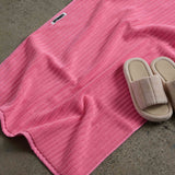 shoes next to pink bath mat