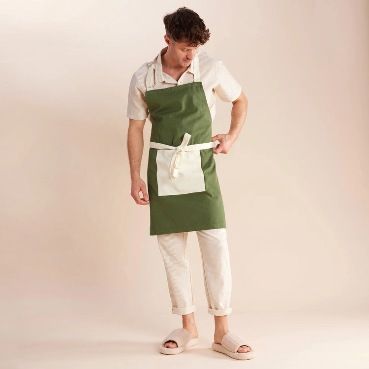 guy standing in cream and green apron