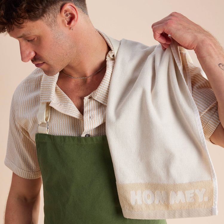 up close shot of guy standing in cream and green apron