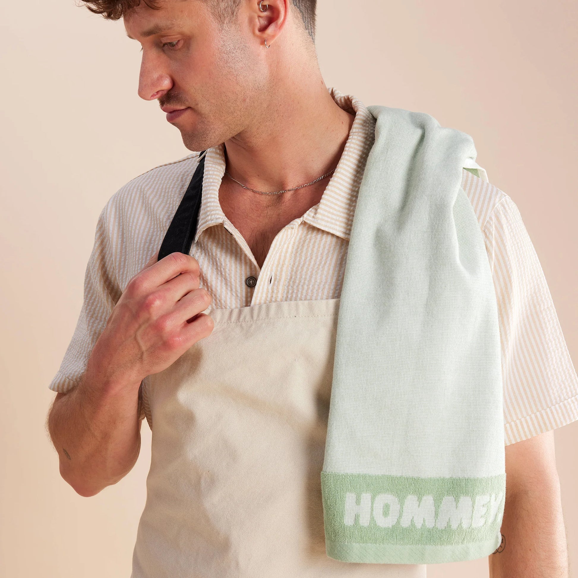 close up shot of guy standing in white and black apron