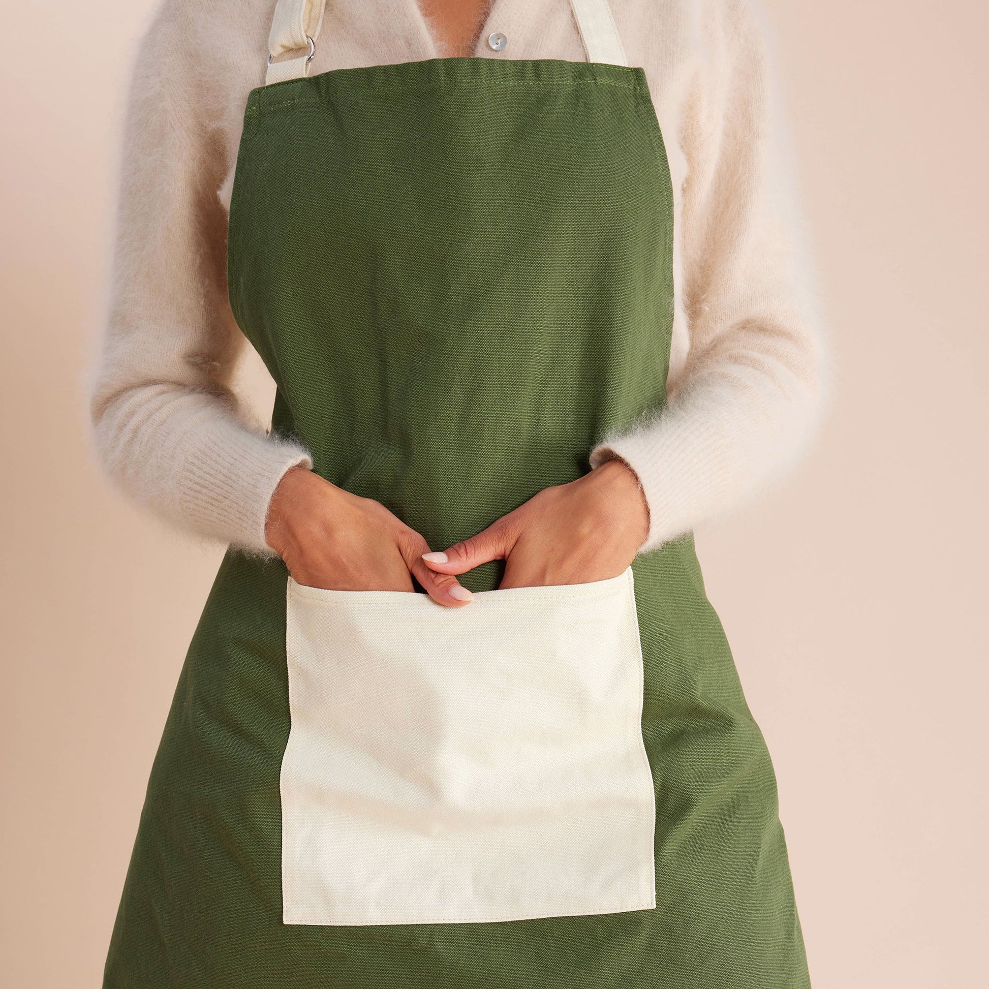 woman standing in cream and green apron