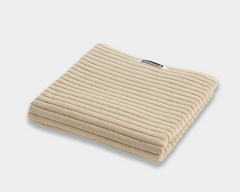 beige bath mat sitting on white background