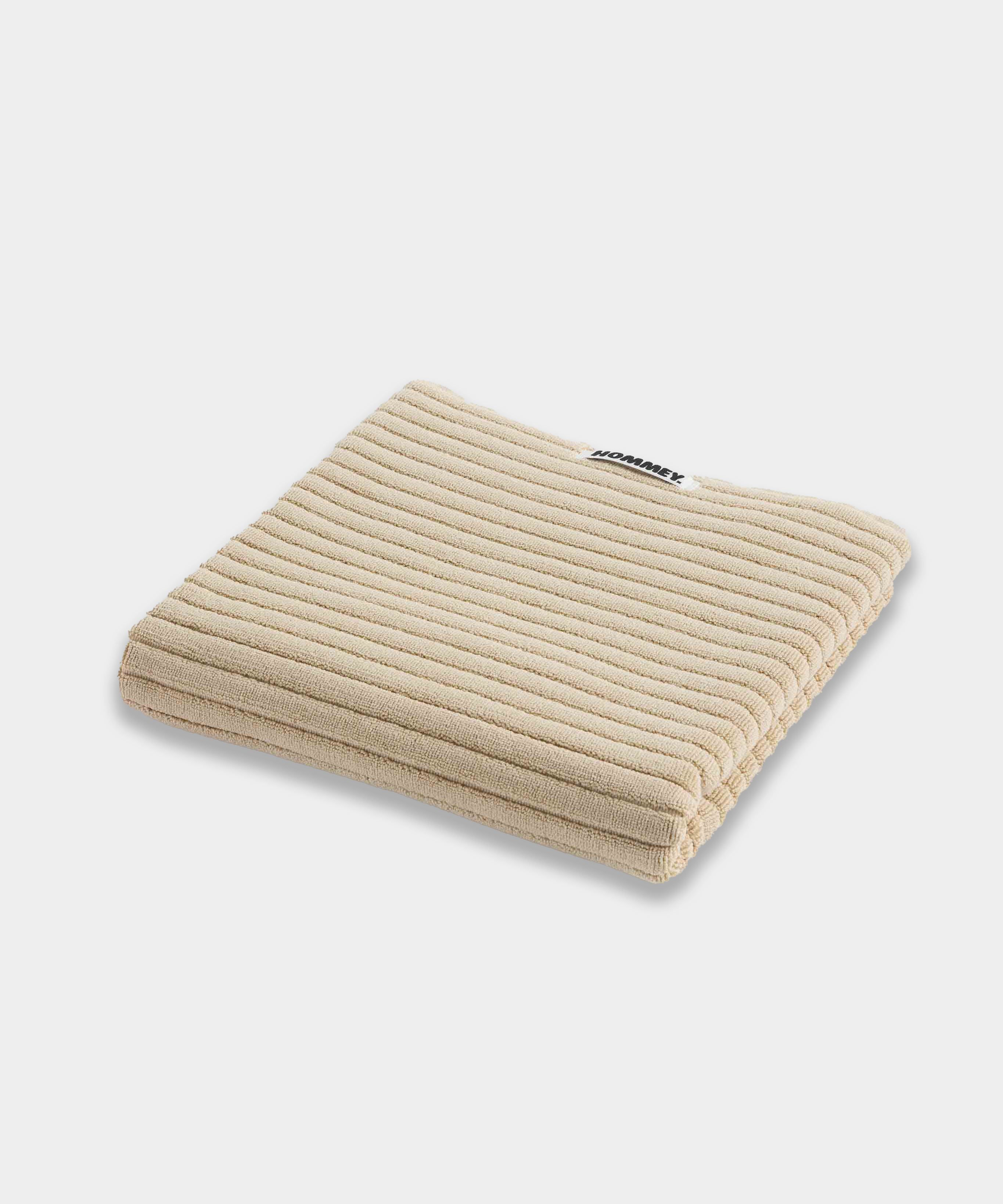 beige bath mat sitting on white background