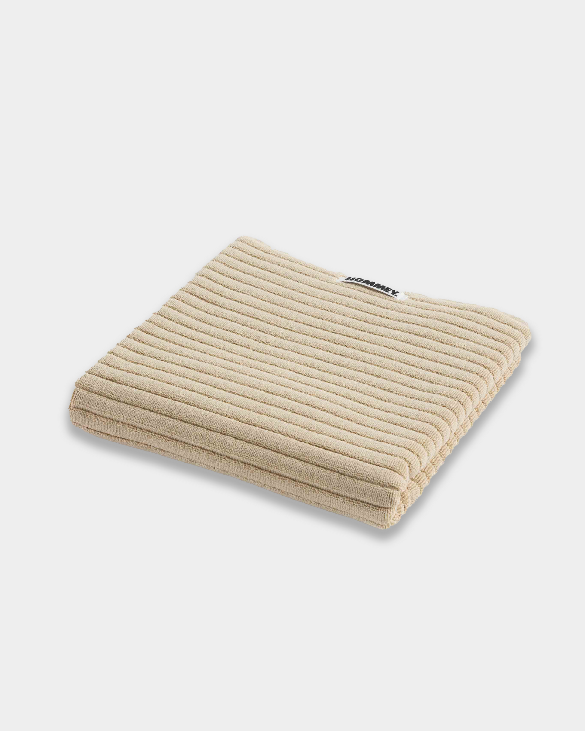 beige bath mat sitting on white background