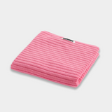 pink bath mat sitting on white background