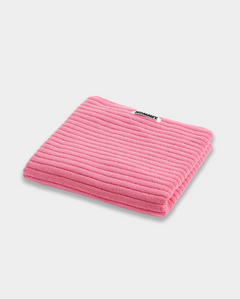pink bath mat sitting on white background