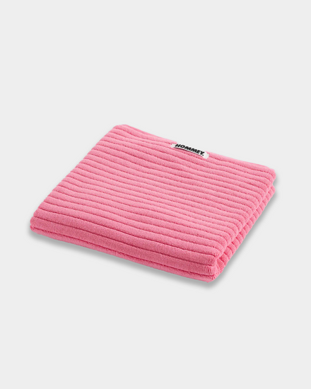 pink bath mat sitting on white background