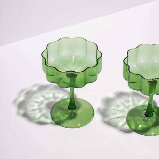 green wave coupe glasses sitting on white background