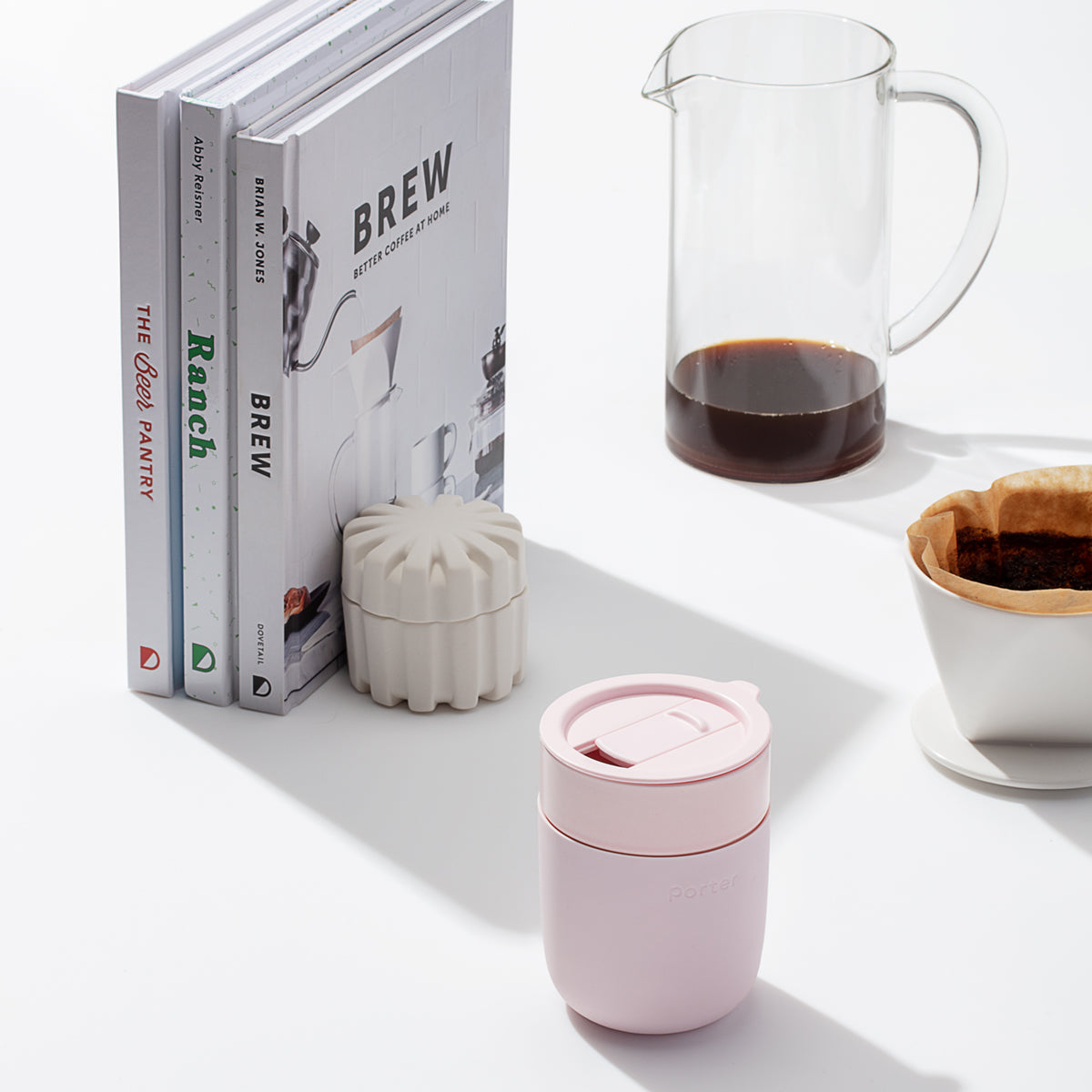 pink ceramic takeaway mug sitting on table