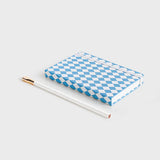 notebook with blue diamond pattern lying down on white background