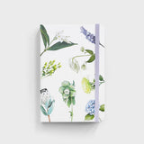 notebook with flowers on it sitting on white background