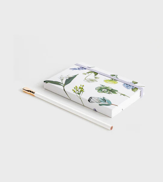 notebook with flowers on it lying down on white background