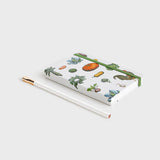 notebook with vegetable pattern lying down on white background
