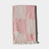 soft pink and white beach towel folded 