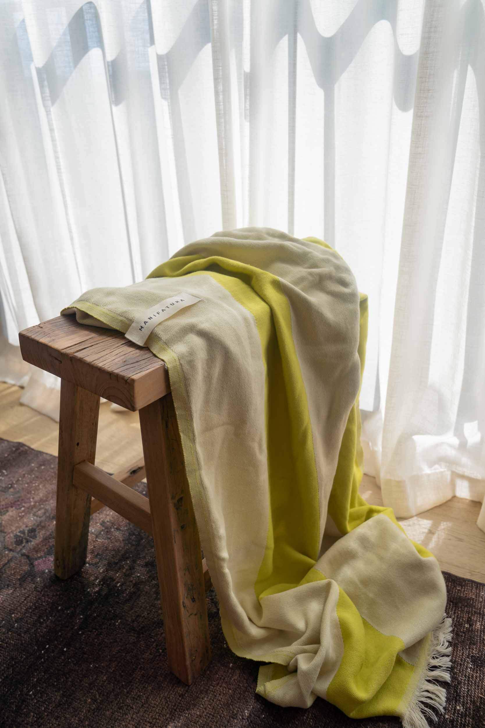 pistachio green and white beach towel draping over a stool 