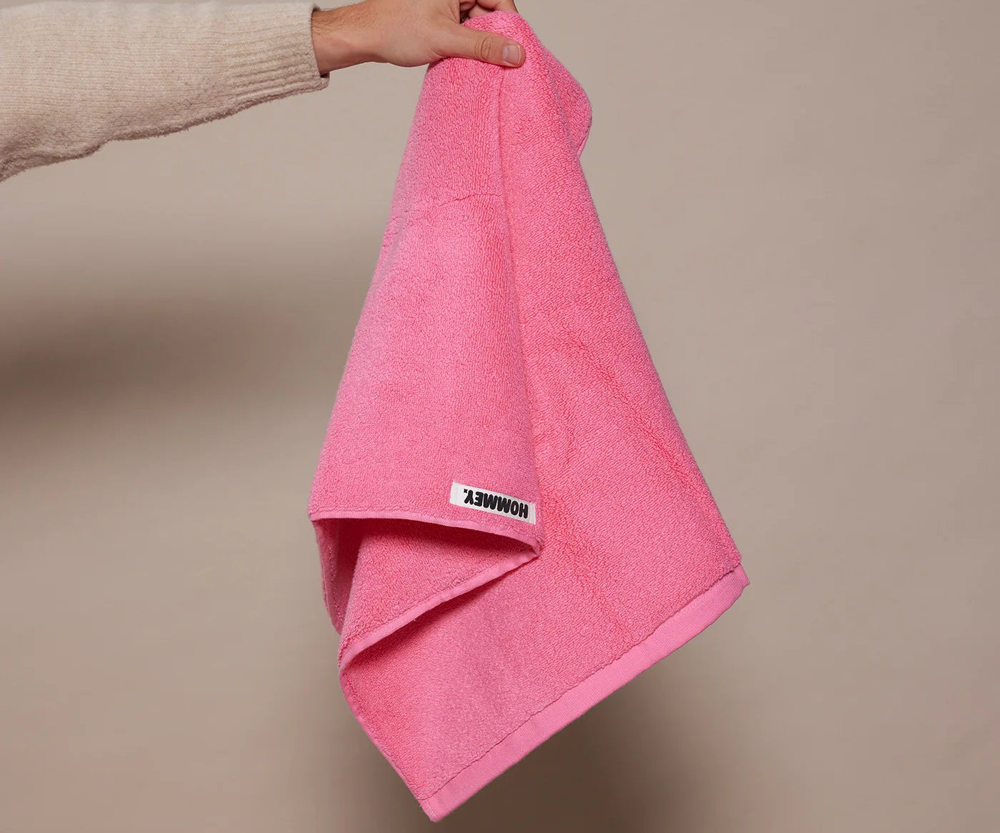 woman holding up pink towel